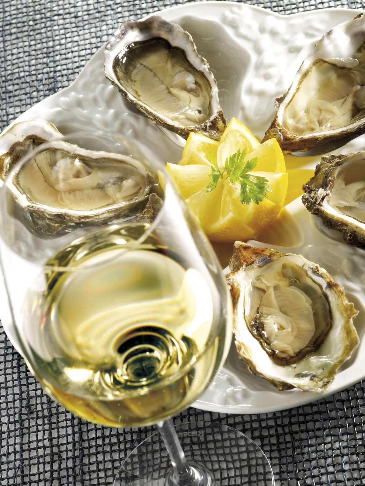 A plate of oysters served with a glass of Chablis